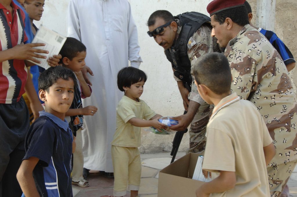 An Iraqi soldier gives a little girl a Halal meal in Amarah, Iraq on July 4, 2008. The meals were handed out to build a relationship with the people of Amarah. (U.S. Army photo by Spc. Lester Colley/Released)